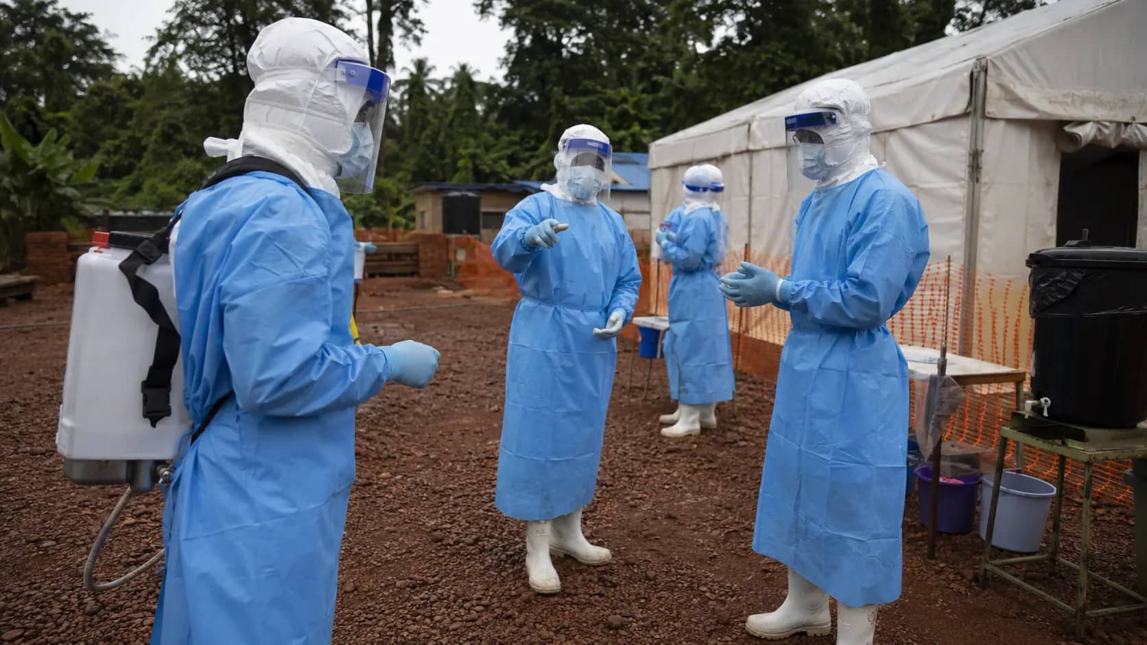Healthcare workers wearing protective equipment outside an Ebola treatment facility in the Democratic Republic of the Congo.