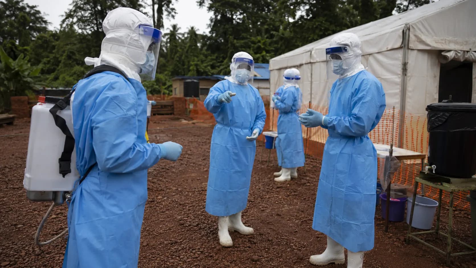 Healthcare workers wearing protective equipment outside an Ebola treatment facility in the Democratic Republic of the Congo.