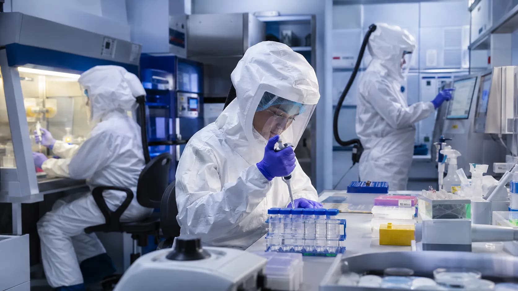 Scientists working with protected laboratory samples during infectious-disease vaccine research.
