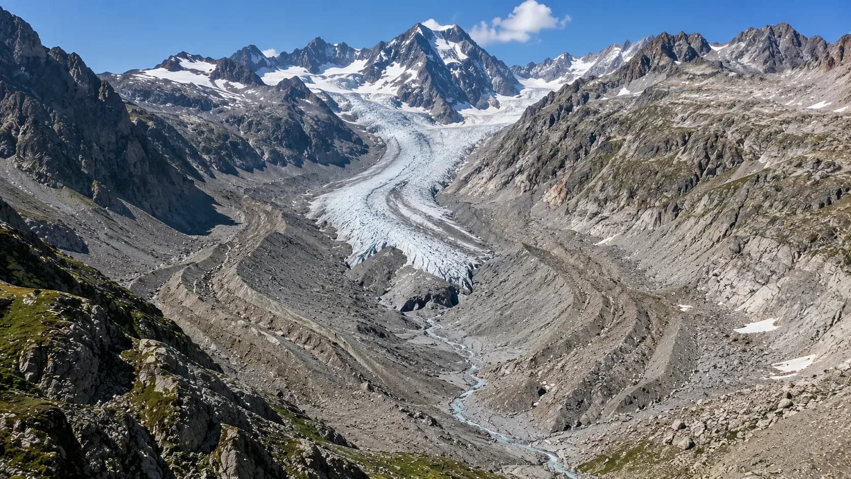 A retreating Alpine glacier surrounded by exposed rock and moraine ridges in a high mountain valley.
