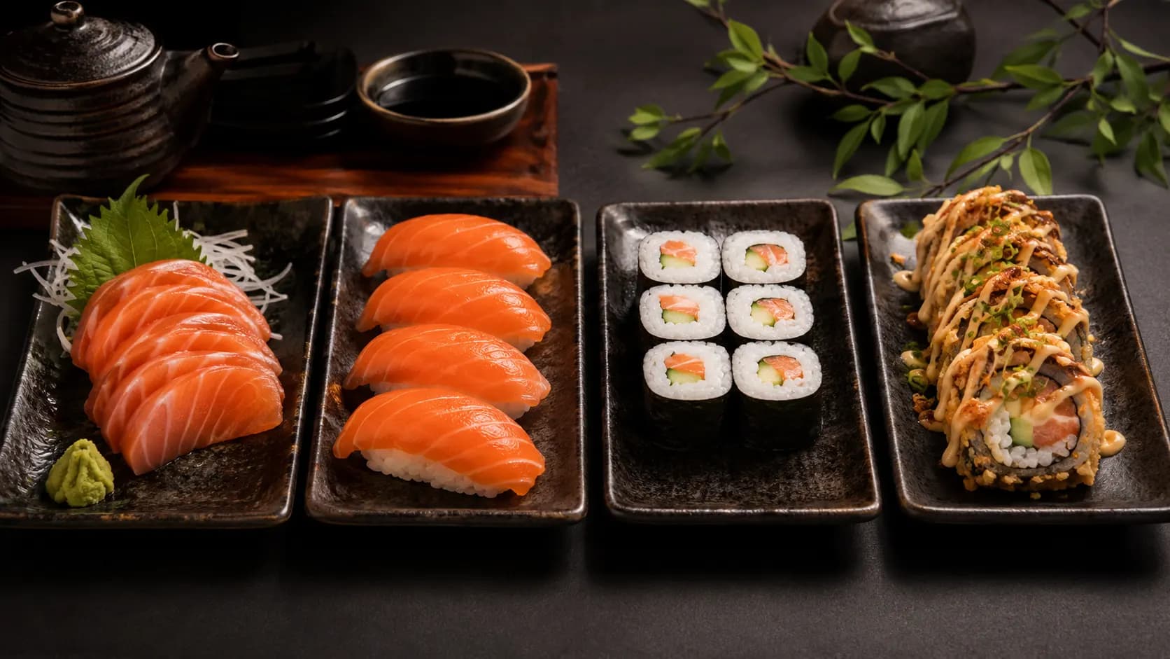 Servings of salmon sashimi, salmon nigiri, a simple maki roll and a fried specialty sushi roll.