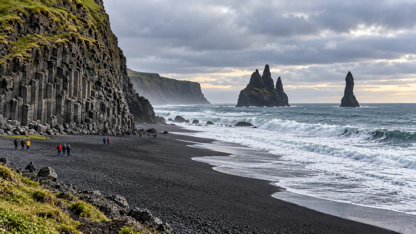 ALT TEXT: A black volcanic shoreline with basalt cliffs, offshore sea stacks and powerful Atlantic waves in South Iceland.