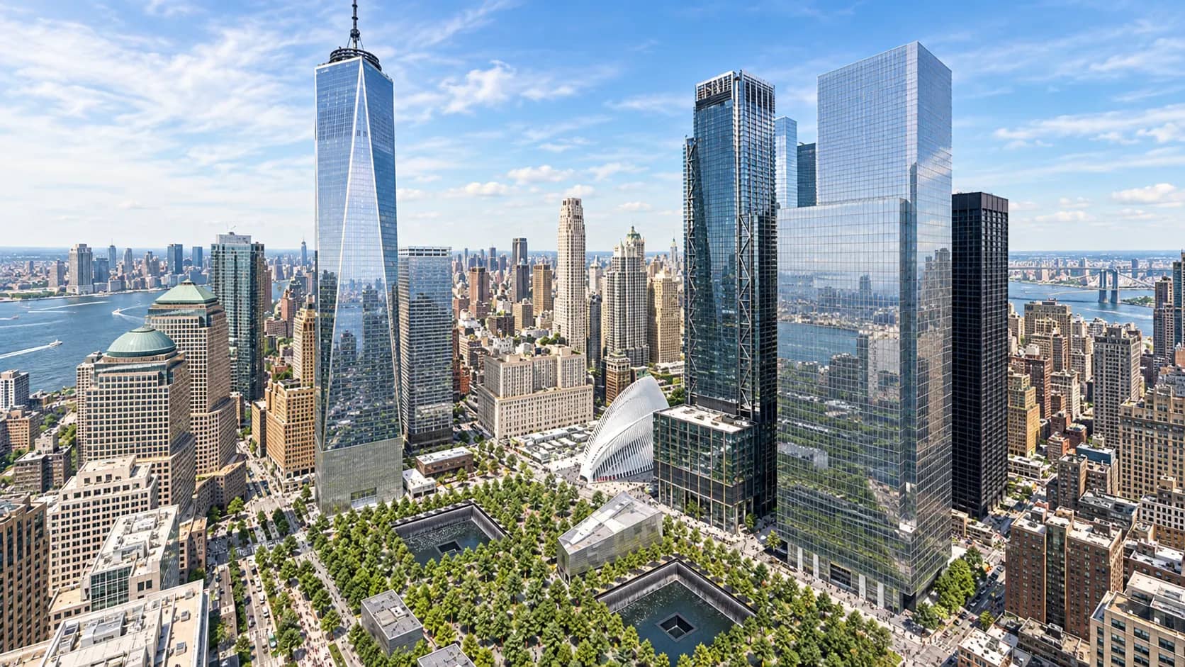 An aerial view of the World Trade Center campus showing One World Trade Center beside the two 9/11 Memorial pools.